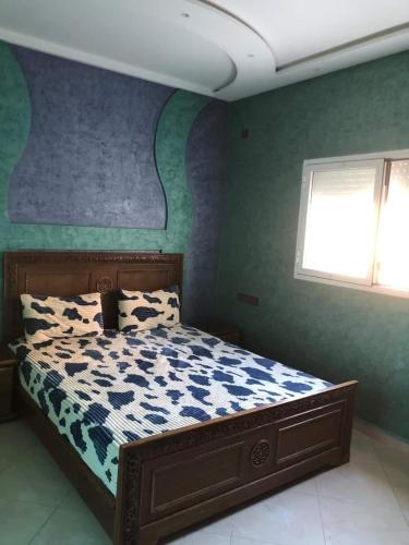 非斯مولاي عقوب的一间卧室配有一张蓝色和绿色的墙壁。