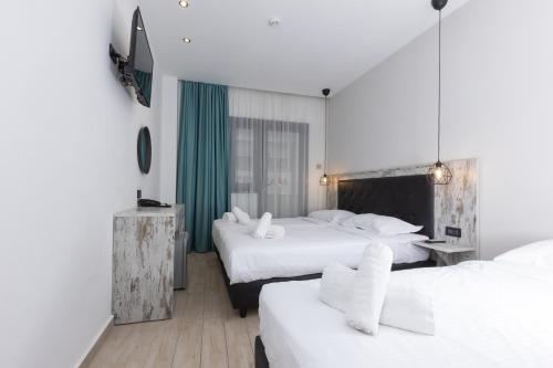 雅典Evita Asty的酒店客房,配有两张带白色床单的床