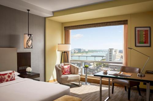 艾哈迈达巴德艾哈迈达巴德凯悦酒店的配有一张床、一张书桌和一扇窗户的酒店客房