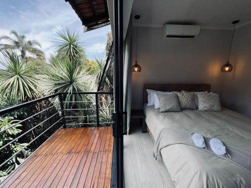 约翰内斯堡Panorama Guest House的一间卧室设有一张床和一个棕榈树阳台