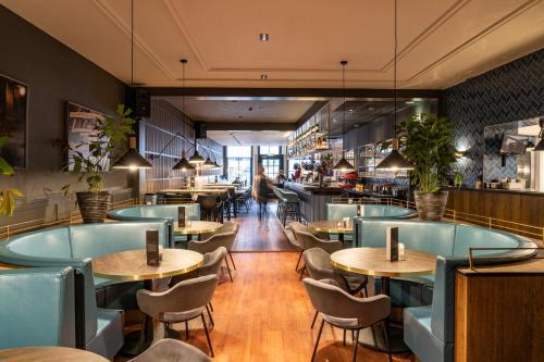 弗拉讷克道伦咖啡馆酒店的一间设有蓝色桌椅的餐厅和一间自助餐厅