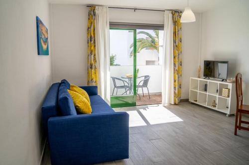 科斯塔德安提瓜New & Renovated Vacation Apartment的客厅配有蓝色的沙发和桌子