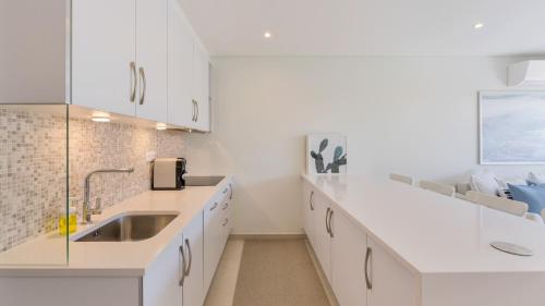 阿尔曼萨Keiko的厨房配有白色橱柜和水槽