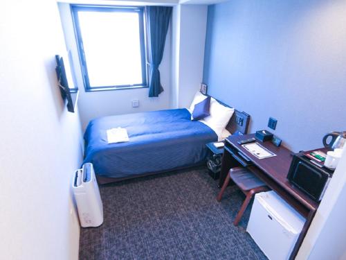 东京HOTEL LiVEMAX Akasaka的配有一张床、一张书桌和一扇窗户的酒店客房