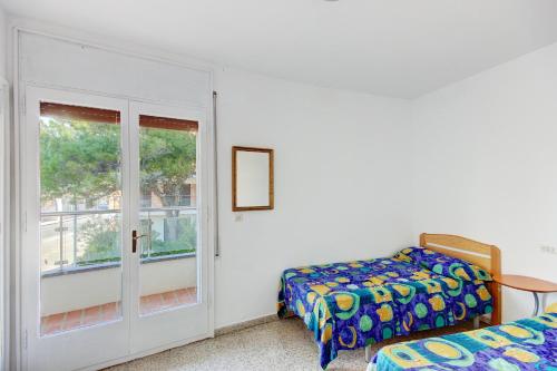 罗萨斯Punta Pelegri 320 Roses - Immo Barneda的一间卧室设有一张床和一个窗口