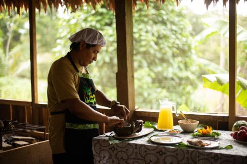 YucurucheEywa Lodge Amazonas - All inclusive的坐在厨房里餐桌上准备食物的人