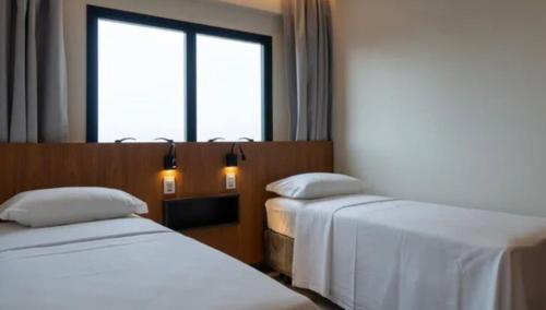 萨利诺波利斯SALINAS PREMIUM RESORT的酒店客房设有两张床和窗户。