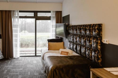 荷兰之角Hotel Torpedoloods的酒店客房设有一张床和一个大窗户
