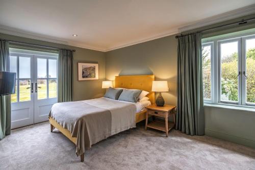 斯托克拜奈兰德The Crown Inn的一间卧室设有一张床和两个窗户。