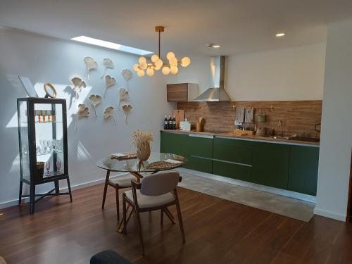 比索达雷加Casa do Romezal的厨房配有绿色橱柜和桌椅