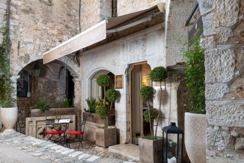 圣保罗-德旺斯圣保罗酒店的石头建筑中的餐厅,配有桌椅