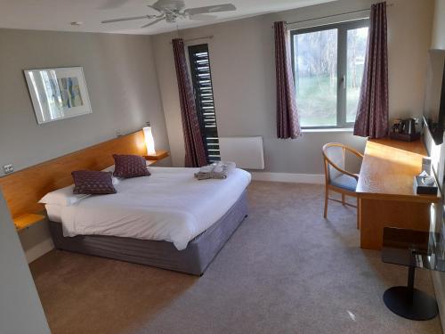 霍舍姆Roffey Park Institute的一间卧室配有一张床、一张书桌和一个窗户。