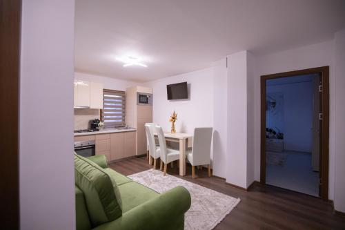 特尔古奥克纳Apartament Gold的客厅配有绿色沙发和桌子
