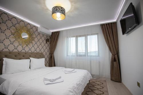 特尔古奥克纳Apartament Gold的一间卧室配有一张带白色床单的床和一台电视。
