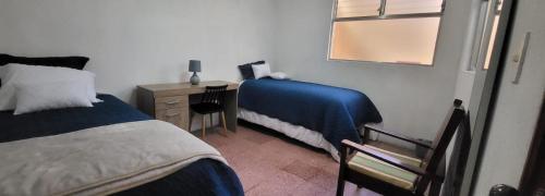克萨尔特南戈Casa para viajes de descanso o de negocios的一间卧室配有两张床和一张带镜子的书桌