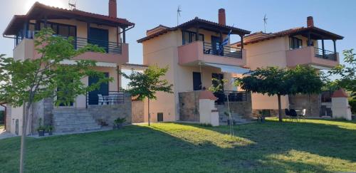 奥马斯帕纳吉亚斯Trifili Villas的庭院顶部带两个阳台的房子