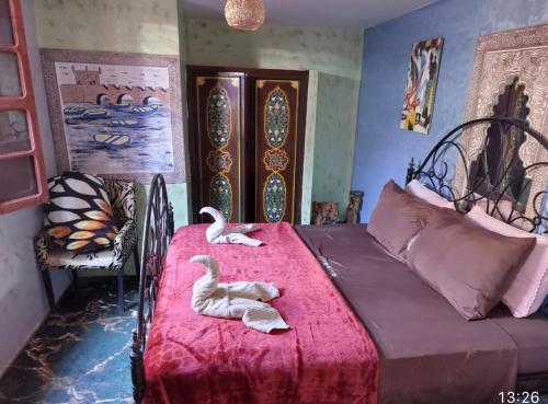 马拉喀什马拉喀什鲁热旅馆的卧室里床边的两只天鹅