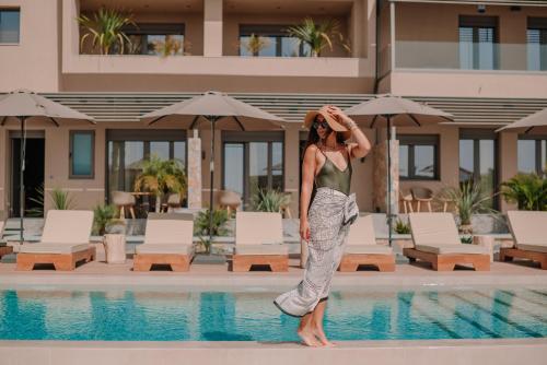 卡特罗斯Marble Luxury Suites的站在游泳池旁的女人