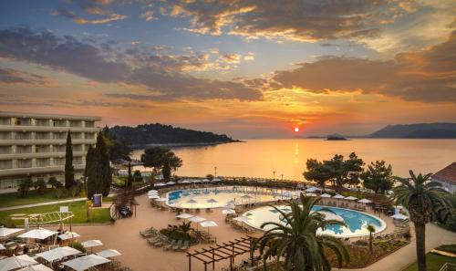 察夫塔特Remisens Hotel Albatros-All inclusive的享有日落的度假村游泳池景致