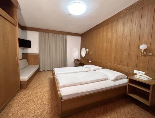 卡尔达罗Roter Adler的一间酒店客房,一间设有床铺、浴缸和床。
