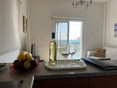 拉纳卡忒弥斯公寓的厨房柜台上的一瓶葡萄酒和两杯酒
