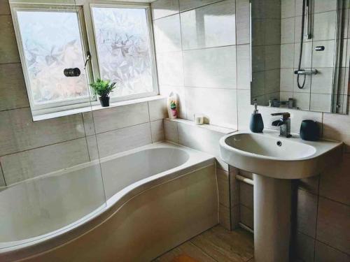 HandsworthHidden Gem !Stunning 3 bedroom home in Sheffield的带浴缸、水槽和窗户的浴室