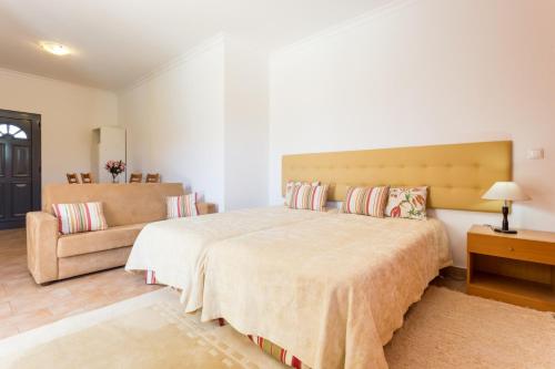 卢斯艾斯特迪奥斯蒙特豪斯达鲁兹酒店的一间卧室配有一张大床和一张沙发
