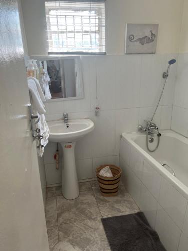 卢萨卡Mukala Lodge的浴室配有盥洗盆、浴缸、盥洗盆和卫生间。