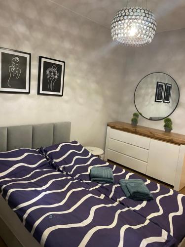 普沃茨克Apartament Mazovia Prestige的一间卧室配有一张带蓝白色毯子的床