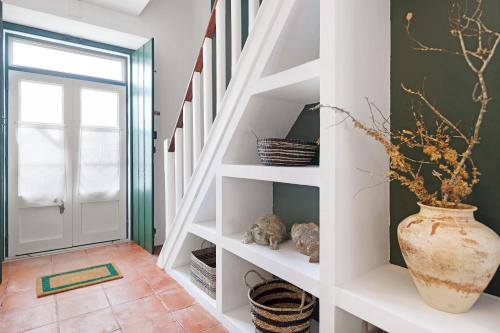 阿尔科谢蒂Casa da Praia的白色架子的楼梯和花瓶