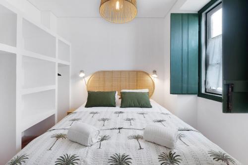 阿尔科谢蒂Casa da Praia的一间卧室配有一张带绿色枕头的大床