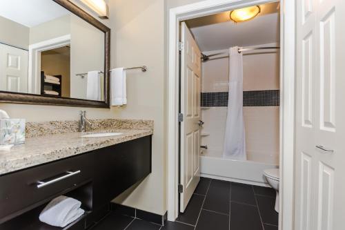 格兰福克大福克斯驻桥套房酒店的一间带水槽、卫生间和镜子的浴室