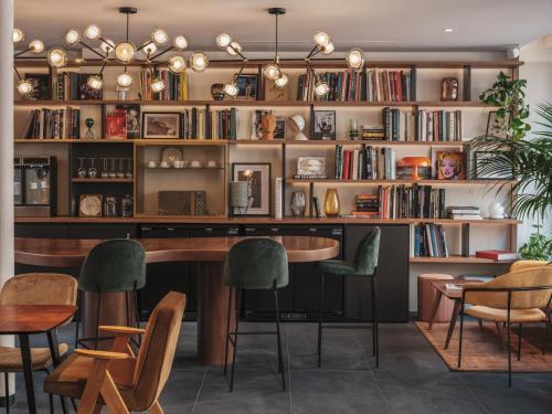 巴黎赛文酒店的图书馆配有桌椅和书架