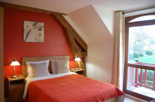 谢夫勒斯Gîte dans un Domaine Historique的卧室设有红色墙壁、一张床和一个窗户