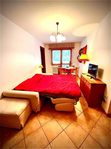 塔尔维西奥Stella Alpina的一间卧室配有红色的床和一张书桌