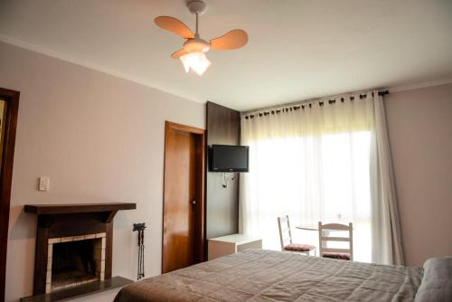新彼得罗波利斯维拉韦德酒店的一间卧室配有一张床和吊扇