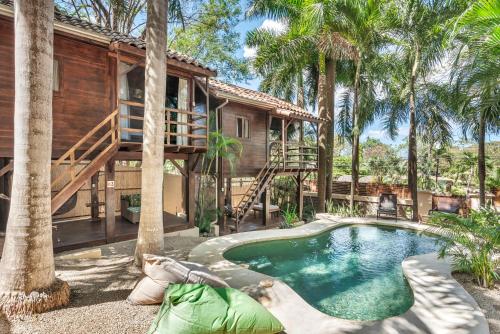 塔马林多The Beach Bungalows - Yoga and Surf House - Adults Only的一座带游泳池和棕榈树的房子
