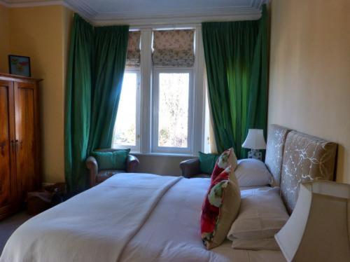 乔利Inglewood的一间卧室配有一张带绿色窗帘的大床