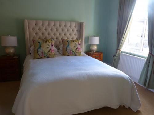 乔利Inglewood的卧室配有白色床、两盏灯和一扇窗户。