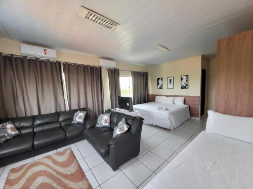 帕劳阿佩巴斯Carajas Hotel的客厅配有沙发和1张床