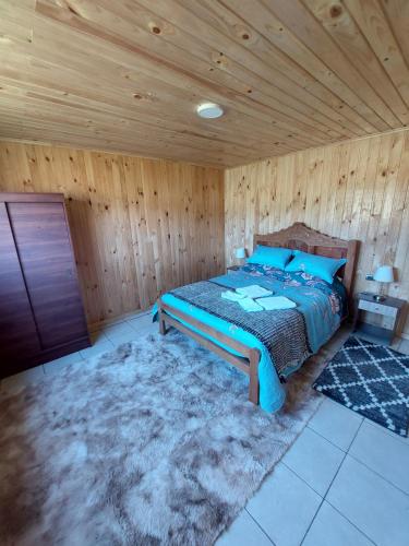 Curaco de VelezCabaña Loft Curaco de Vélez的一间卧室设有一张床和木制天花板