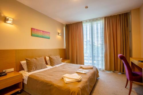 İznikOlive Garden Hotel的配有一张床、一张书桌和一扇窗户的酒店客房