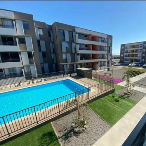 阿里卡Departamento Amoblado en Arica的公寓大楼前的游泳池