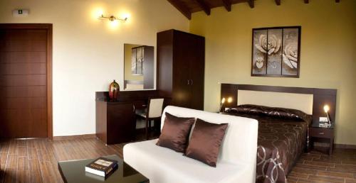 达拉索Villa Koulouridi的一间卧室配有一张床、一张沙发和一张桌子