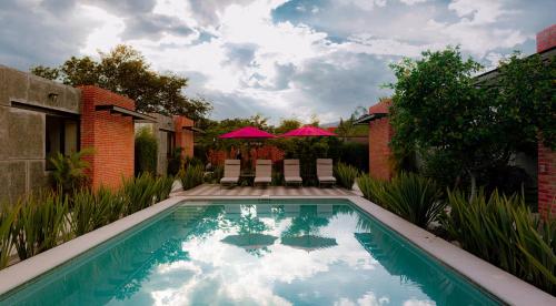 阿吉吉克Casa 8 Maltas的一座带粉红色遮阳伞的别墅后院游泳池