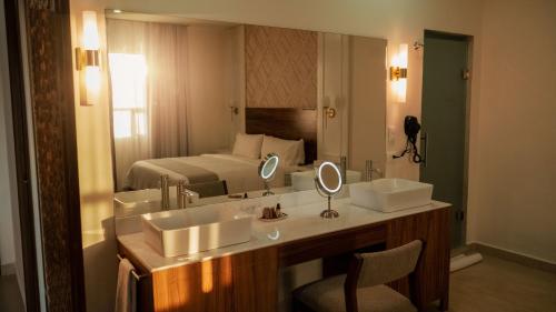 圣卡洛斯Casa Maria Boutique Hotel的一间带两个水槽和一张床的酒店浴室
