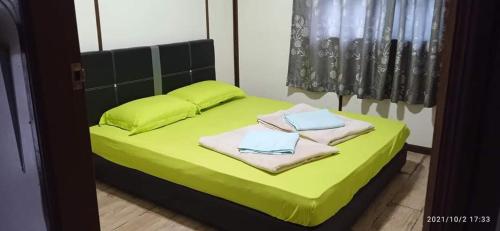 昆达桑Dongorit Cabin House 1的一间卧室配有绿床和毛巾