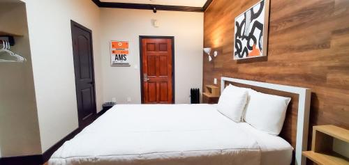旧金山阿姆斯特丹旅舍的卧室配有白色的床和木墙