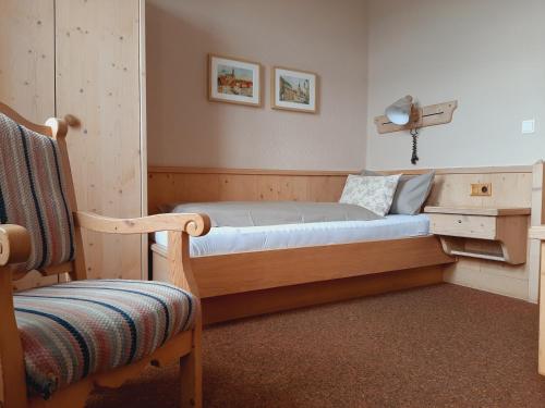 FalkenauRestaurant & Hotel Zur Falkenhöhe的一间卧室配有一张带桌子和椅子的床