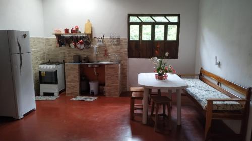 帕尔梅拉斯Casa Quaresmeira的一间带桌子的厨房和一间带冰箱的厨房